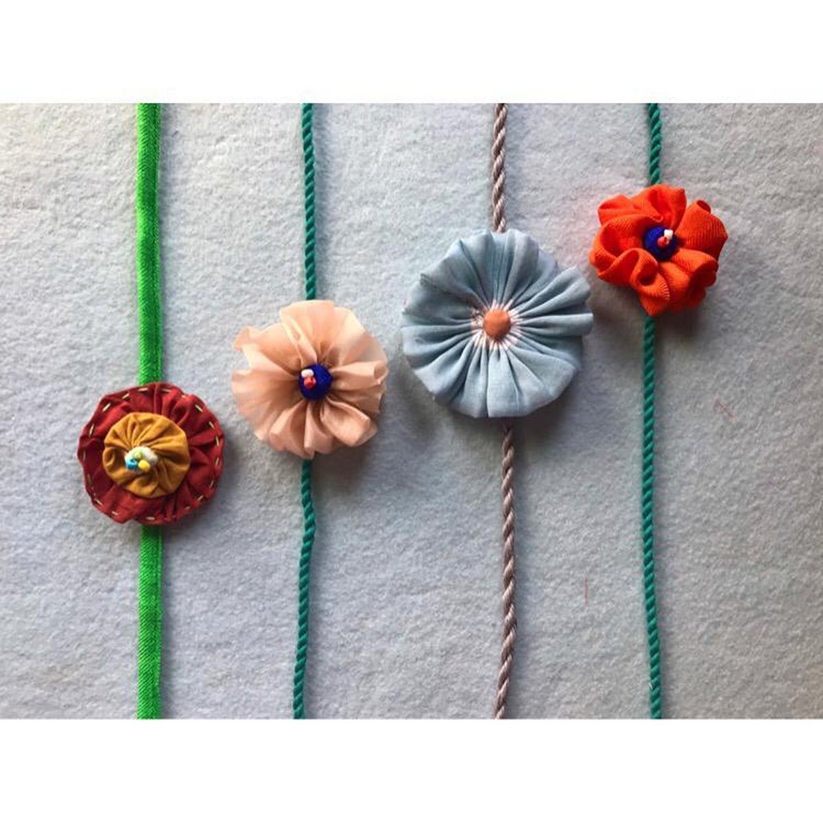 Upcycled Handmade Flower Power Rakhi Combo (Pack of 4) – Rakhi by USE ME WORKS available on Brown Living™. . SKU: UMW - Combo - Rakhi - 06. Img 1.